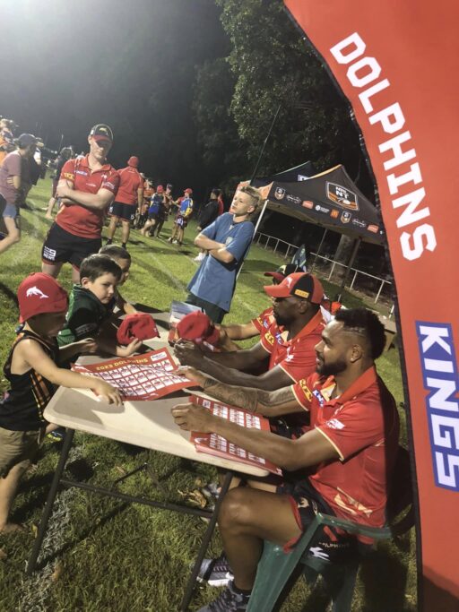 Dolphins NRL players signing autographs for local children at a community event supported by Tamboran Resources